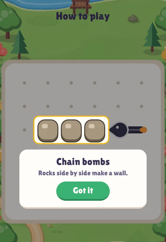The How to play lesson Chain bombs: a wall of three stone rocks and a chain bomb aimed at it